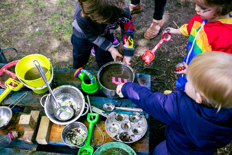 Children play with a mud kitchen.