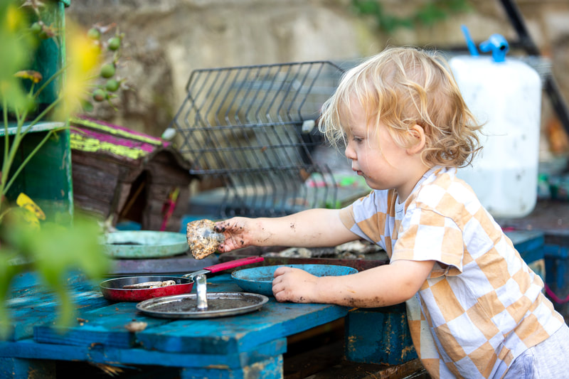 A child plays with a mud kitchen.